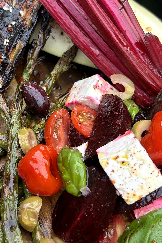 Grilled vegetables, roasted peppers, beetroot and feta on a wooden sharing board