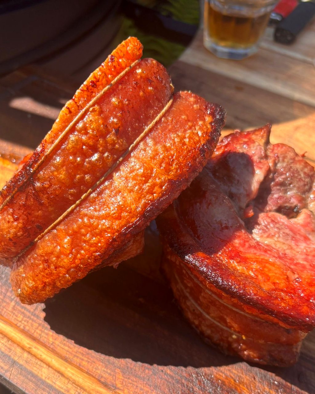 Slow-roasted pork belly with crisp golden crackling on a wooden board, cooked by Light & Salt in Furness