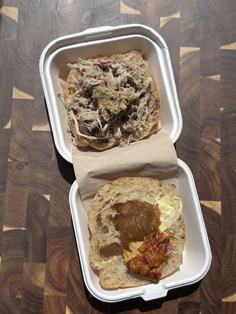 Open box with a pulled pork and crackling bap from Light & Salt Provisions.