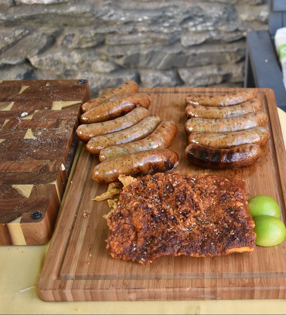 A wooden board of freshly cooked sausages with pork crackling and lime from Light & Salt Provisions, Lindal.